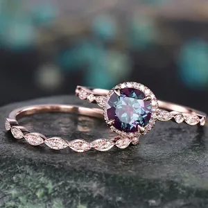 Rose gold alexandrite wedding ring set with halo round center stone on dark rock