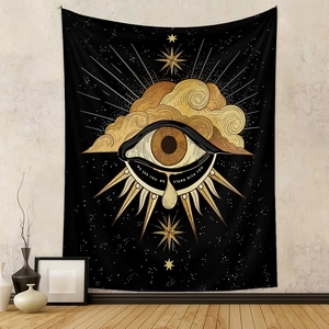 Detail of wall tapestry featuring gold eye and clouds with WE SEE YOU text on black fabric