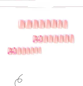 Detail of pink French press-on nails featuring heart patterns and square short style