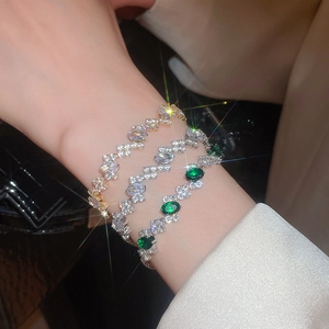 Detail shot of elegant zircon oval bracelets in gold, silver and emerald green stones