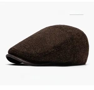 Detail of coffee brown vintage newsboy cap showing textured fabric and leather brim trim