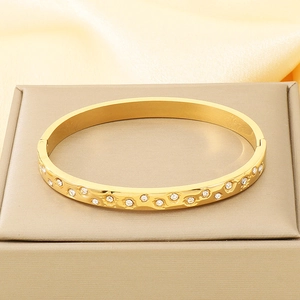 Detailed close-up of 18K gold plated bangle with hammered texture and sparkling rhinestones