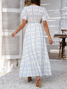 Back view of bohemian white and blue print dress in a sunlit Mediterranean courtyard