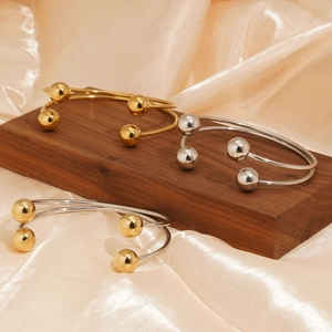 Minimalist stainless steel open bangle with double spheres in gold and silver finishes