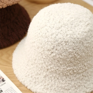 Close-up of soft lamb wool texture on a white knit bucket hat for winter fashion