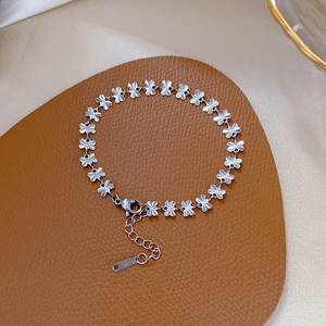 Detailed macro view of silver clover link bracelet in durable stainless steel