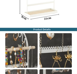 Detailed view of white metal jewelry stand with wooden base showing hooks and earring holes