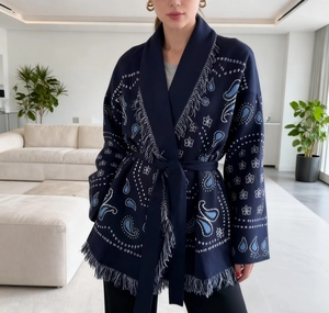 Detail of navy blue paisley knit cardigan featuring fringed edges and bohemian patterns