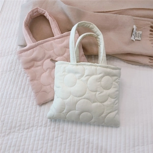 Dettaglio di mini borse shopper trapuntate a fiori in rosa e crema con chiusura a zip