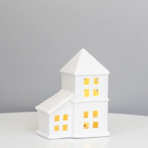 Minimalist white ceramic house LED night light decoration on a neutral background