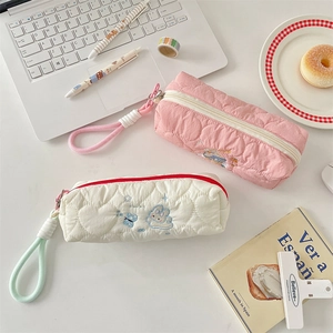Detailed view of quilted cotton pencil cases with cute rabbit embroidery and zip closure