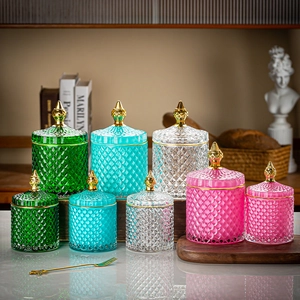 Group display of colorful diamond pattern glass jars with ornate golden lids and varied sizes