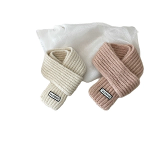 Minimalist knit wool scarf in cream and beige colors with a stylish woven label
