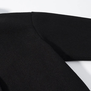 Gros plan des coutures d'épaule et du tissu épais sur le manteau noir en laine