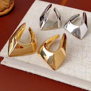 Close-up of geometric gold and silver earrings placed on a book for elegant detail
