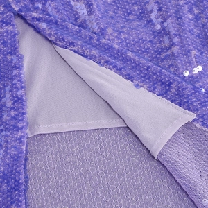 Dettaglio delle paillettes viola e della fodera interna di un abito da festa scollato