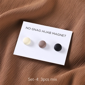 Three matte magnetic pins for scarves in beige, brown, and black colors on a white card