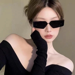 Close-up of black geometric rectangular sunglasses on model showing sharp modern frame
