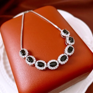 Detail of silver chain bracelet with oval black stones and sparkling zircon pavé