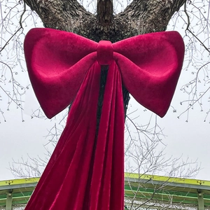 Giant burgundy velvet decorative bow tied on tree for outdoor festive events decoration