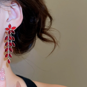 Nahaufnahme eleganter roter Kristall-Blumenohrringe mit langen Quasten an einem Model