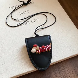 Black leather dachshund dog necklace with cute cartoon pendant on a rustic book background