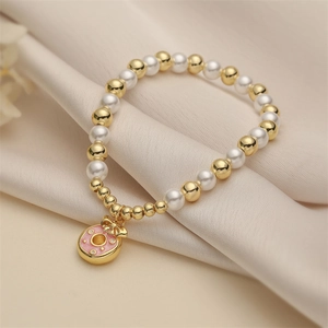 Pink heart donut pendant bracelet with white pearls and gold beads on silk fabric