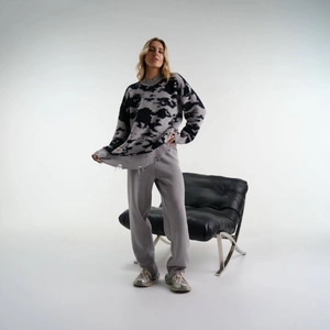 Nahaufnahme des grauen Camouflage-Strickpullovers mit Distressed-Details und Rundhals