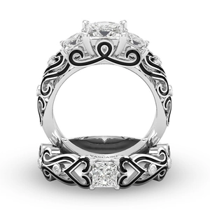 Detailopname van zilverkleurige zirkonia ringen met hart- en wijnstokpatroon gravures