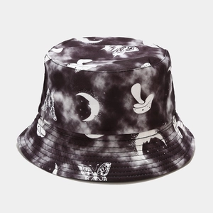 Dettaglio del cappello pescatore in cotone tie-dye bianco e nero con farfalle e funghi