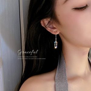 Elegant gold tassel earrings with rhinestone pendants worn by a model for a chic look
