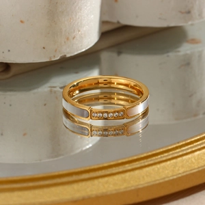 Detailed macro view of a gold-plated stainless steel ring with white shell inlay and zircon