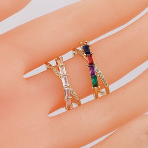 Detail of gold-plated crossover rings with colorful baguette-cut crystals and pavé settings