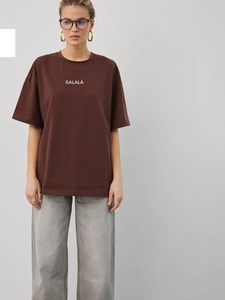 Detail eines dunkelbraunen Oversized-Baumwoll-T-Shirts mit weißem GALALÁ-Printdesign