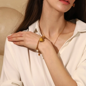 18K gold plated chain bracelet with heart pendant and pearl on female model