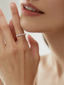 Close-up of elegant rose gold S925 silver seven-stone row ring worn on a finger