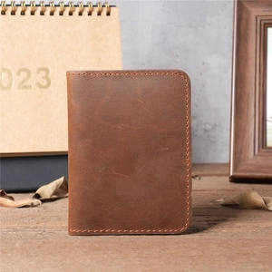 Vintage brown crazy horse leather wallet for men on wood table with rustic studio backdrop