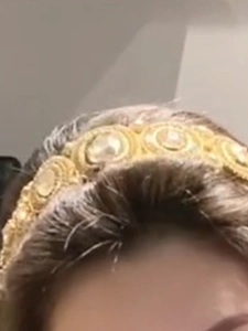 Macro detail of luxury vintage gold hairband featuring sparkling crystals and white pearls