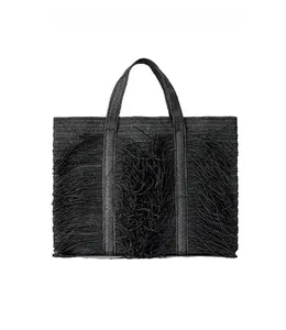 Close-up of black woven tote bag featuring long decorative tassels and woven handles