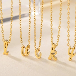 Detail einer minimalistischen Goldkette mit fünf Buchstabenanhängern, die lucky buchstabieren