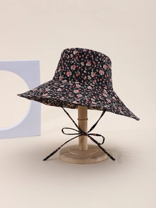 Detail of floral wide brim sun hat with pink floral pattern on black fabric and chin strap