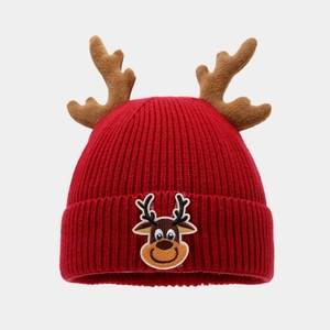Detailed view of red knitted Christmas beanie with 3D reindeer horns and embroidery