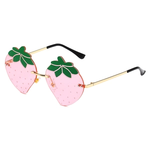 Frameless strawberry shaped sunglasses with pink lenses and gold metal frame on white background