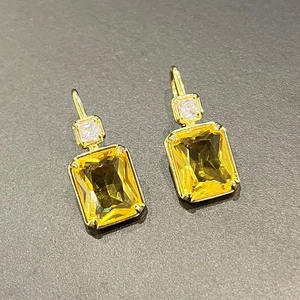 Detail van gele rechthoekige edelsteen oorbellen met gouden haken en zirkonia