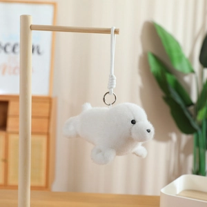 Close-up of fluffy white seal plush keychain hanging on a minimalist wooden display stand
