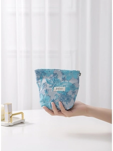 Handheld blue floral jacquard makeup bag with elegant embroidery and H&R brand label