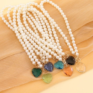 Seven multicolored heart crystal pearl necklaces with gold toggle clasps on silk