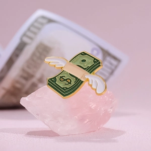 Creative flying dollar bill enamel pin with white wings on pink stone background
