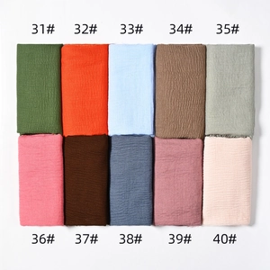Flat lay display of 10 solid color crinkle cotton scarves with numbered color swatches
