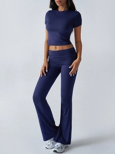 Detail view of navy blue yoga set featuring a short sleeve crop top and flared leggings